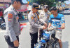 Kapolsek Buay Pemaca Pasangkan Bendera ke Motor Warga
